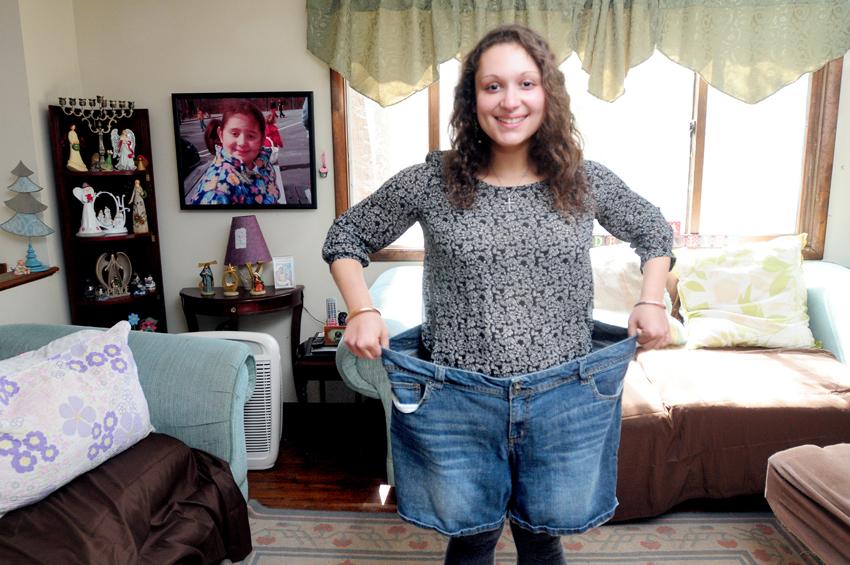 (Arnold Gold-New Haven Register) University of Rhode Island senior Brianna Blank, 21, is photographed in the living room of her home in Westbrook on 4/12/2014 with a pair of shorts she wore when she was 150 pounds heavier.